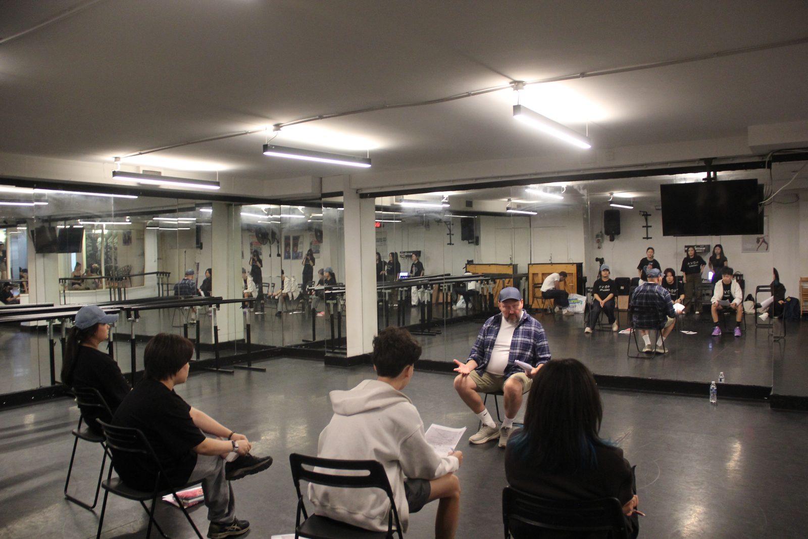 Students performing for practitioners in a large studio